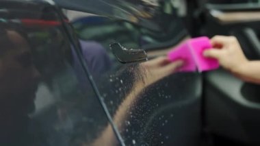 Bir arabaya koruyucu PPF filmi uygulanma süreci. Plaminatın koruyucu filmini uygulayan bir profesyonelin elleri. 
