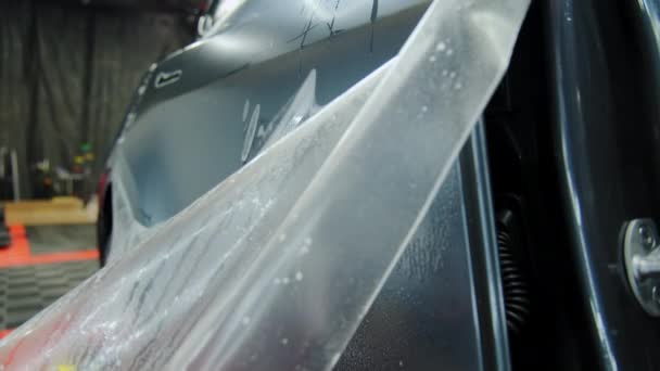 保護Ppfフィルムを車に適用するプロセス ラミネートの保護膜を適用する専門家の手 — ストック動画