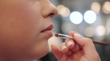 Profesyonel makyöz kadın dudaklarına ruj sürüyor. Yüksek kalite 4k görüntü
