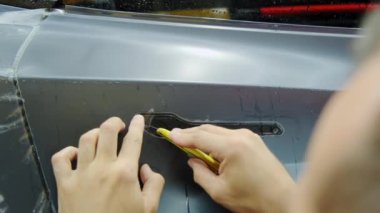 Bir arabaya koruyucu PPF filmi uygulanma süreci. Bir profesyonelin elleri laminatın koruyucu filmini uyguluyor. - Evet. Yüksek kalite 4k görüntü