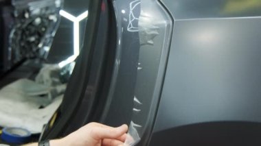 Bir arabaya koruyucu PPF filmi uygulanma süreci. Bir profesyonelin elleri laminatın koruyucu filmini uyguluyor. - Evet. Yüksek kalite 4k görüntü