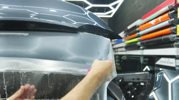 将Ppf保护膜应用于汽车的过程 使用保护膜层压板的专业人员的手 是的高质量的4K镜头 — 图库视频影像