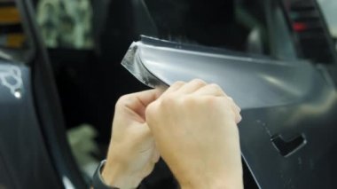 Bir arabaya koruyucu PPF filmi uygulanma süreci. Bir profesyonelin elleri laminatın koruyucu filmini uyguluyor. - Evet. Yüksek kalite 4k görüntü