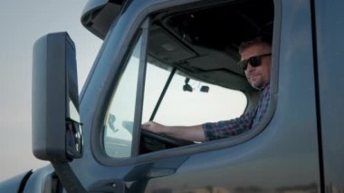 Profesyonel kamyon şoförü kamyonunu sürüyor ve arkasında da Long Haul Semi-Truck var. Yüksek kalite 4k görüntü