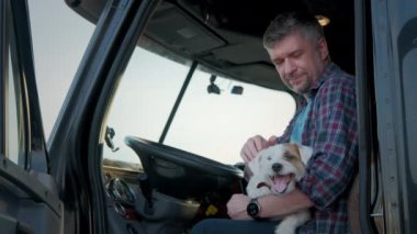 Profesyonel bir kamyoncunun portresi köpekle birlikte bir tırda oturur. Yakın çekim. Yüksek kalite 4k görüntü