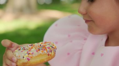 Lezzetli Donut Yiyen Küçük Kız Konsepti. Görüntüleri kapat. Yüksek kalite 4k görüntü