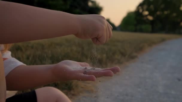 日落时 一个小女孩坐在人行道上玩沙子 靠近点高质量的4K镜头 — 图库视频影像