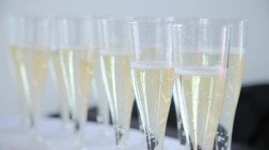 Bubbles in champagne glasses at a table. Move camera shot. High quality 4k footage
