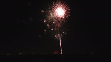 Wide Aerial shot of fireworks in the night sky suitable for July 4th or New Years celebrations. High quality 4k footage