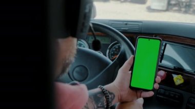 Kamyonetteki sürücü elinde yeşil ekran olan bir telefon tutuyor. Yüksek kalite 4k görüntü