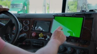 Kamyonetteki sürücü elinde yeşil ekran olan bir tablet tutuyor. Yakın çekim. Yüksek kalite 4k görüntü