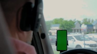 Kamyonetteki sürücünün arka görüntüsünde elinde yeşil ekran olan bir telefon var. - Evet. Yüksek kalite 4k görüntü