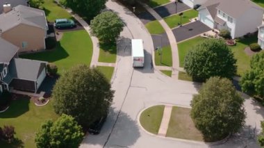 Fedex beyaz kurye minibüsünün banliyödeki varış noktalarına posta ve paket götürdüğü geniş bir görüş alanı. Naperville lL 'de. ABD 25 Haziran 2023. Yüksek kalite 4k görüntü