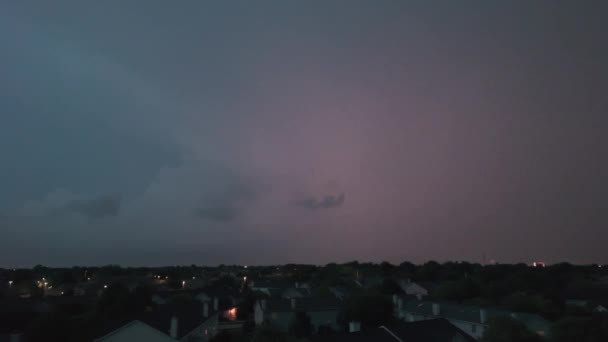 大雨の前に暗い空に形成された嵐の雲のワイドドローンショットと郊外の町のライトアップ 高品質の4K映像 — ストック動画