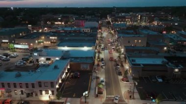 Naperville şehir merkezinde gece vakti geniş bir drone görüntüsü. Arabalar ve insanlar yolda ilerliyor. Naperville lL 'de. Yüksek kalite 4k görüntü