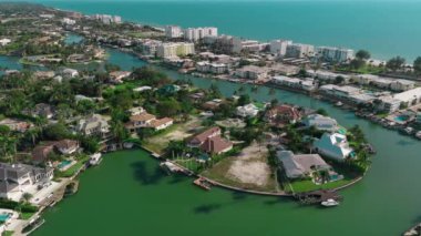 İnsansız hava aracı. Tekne körfezde yelken açıyor, körfezin kıyısında birçok özel ev var. Yüksek kalite 4k görüntü