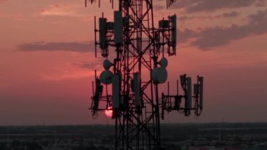 Gün batımında bir şehir manzarasında televizyon ya da radyo telefon kulesi. Hava yakınlaştırma görüntüsü. Yüksek kalite 4k görüntü