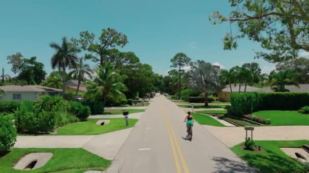 Drone Vista Uma Mulher Monta Uma Bicicleta Entre Palmeiras Verdes — Vídeo de Stock