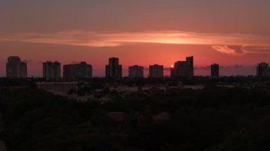 Turuncu gün batımı ve Florida 'daki Napoli kıyılarındaki yüksek binaların siluetleri. İnsansız hava aracı zoom atışı. Yüksek kalite 4k görüntü