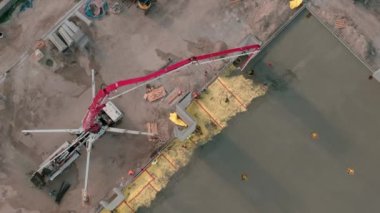 İHA 'lar konut ve ticari inşaat alanlarını tepeden aşağı görüyor, beton kamyonlar zemini boşaltmak için beton karışımı döküyor. Yüksek kalite 4k görüntü