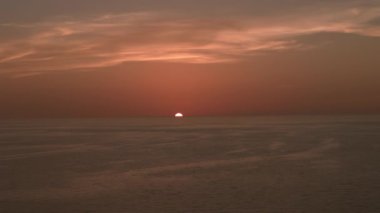 Yanan gökyüzü ve parlayan altın dalgalar. Okyanus sahili gün batımı. Havadan geniş çekim görüntüsü. Yüksek kalite 4k görüntü