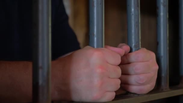 刑務所の監房に立って 金属製の棒を持って 捕虜の手を閉じた 高品質の4K映像 — ストック動画