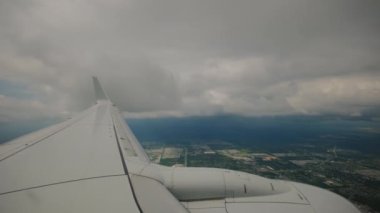 Yolcu tarafından pencerelerden görülen bulutların içinde uçan uçak kanadı. Geniş görüş. Yüksek kalite 4k görüntü