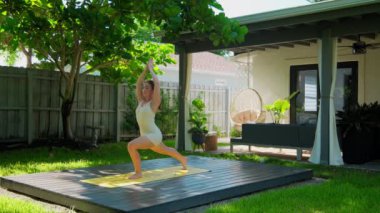 Güzel bir tropikal bahçede çalışırken yoga pozu veren bir kadın. Yüksek kalite 4k görüntü