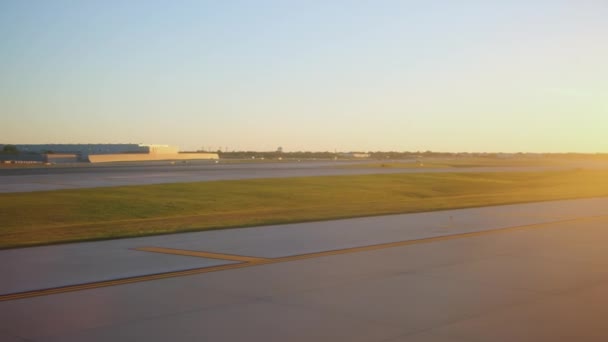 飛行機は日没時にシカゴ国際空港のターミナルでゲートにドライブします ワイドショット 高品質の4K映像 — ストック動画