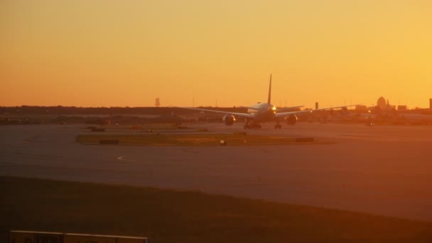 飛行機はシカゴ国際空港のターミナルでゲートにドライブします 日没時にワイドショット 高品質の4K映像 — ストック動画
