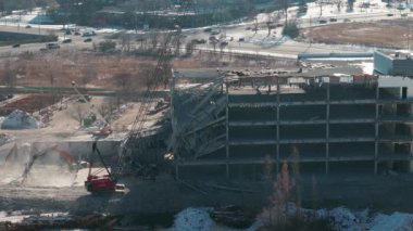 Yıkılan binaların geniş çaplı drone görüntüsü. Binanın yıkılması. Kazıcı bir yıkım alanında çöp gibi çalışıyor. Yüksek kalite 4k görüntü