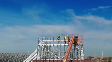 Endüstriyel çatı, çatı tamircileri endüstriyel bir binaya ya da depoya çatı kuruyor. Hava görüntüleri. Yüksek kalite 4k görüntü