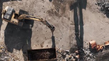 Binanın yıkılması. Kazıcı bir yıkım alanında çöp gibi çalışıyor. Yıkılan binaların insansız hava aracı görüntüleri. Yüksek kalite 4k görüntü