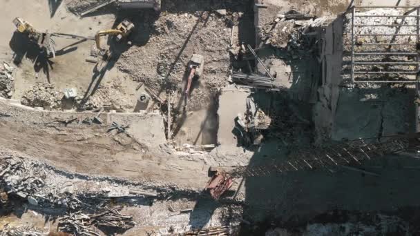 建物の解体について 破壊現場でゴミを処理する掘削機 破壊された建物の映像の下のワイド ドローン 高品質の4K映像 — ストック動画