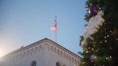 Santa Barbara, California 'daki Noel ağacı elementi, güneşli bir günde palmiye ağaçları ve Amerikan bayrağının arka planına karşı. Yüksek kalite 4k görüntü