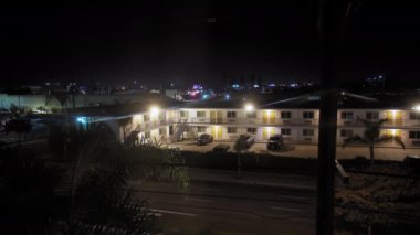 Palmiye, Kaliforniya 'nın gece vakti palmiye ağaçlarıyla çevrili olduğu geniş bir sokak görüntüsü. Yüksek kalite 4k görüntü