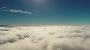 Güneşin altında beyaz kabarık bulutların içinden uçar. Geniş görüş alanı. Yüksek kalite 4k görüntü