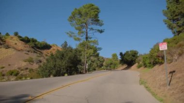 POV, güneşli bir günde Hollywood Tepesi kırsalında araba sürüp, imza ve gözlemevine giderken geniş bir görüntü yakaladı. Kaliforniya, ABD. Yüksek kalite 4k görüntü