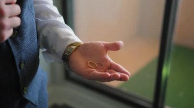 Damat alyansları elinde tutuyor, yakın çekim. Yüksek kalite 4k görüntü