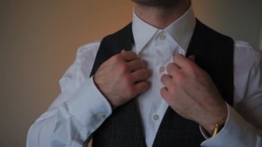 Karanlık odada ceketini giyen bir damat. Yakın çekim. Yüksek kalite 4k görüntü