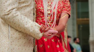 Geleneksel Hint kıyafetleri giyip el ele tutuşan çift, Hindu düğünü. Kapatın. Yüksek kalite 4k görüntü