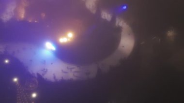 Geniş insansız hava aracı görüntüsü Millennium parkındaki buz pateni sahasında gece sis saatinde birçok insan kayıyor. Şikago. Yüksek kalite 4k görüntü