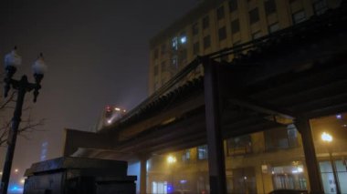 Sisli bir gecede Yükseltilmiş Pist 'ten geçen tren. Chicago şehir merkezinde metro. Geniş açı. Yüksek kalite 4k görüntü