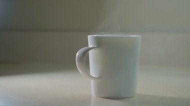 Bir el beyaz bir fincan alır ve masadan kahve alır. Yakın çekim. Yüksek kalite 4k görüntü