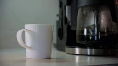 Bir el kahveyi fincana koyar ve masadan beyaz bir fincan alır. Kapatın. Yüksek kalite 4k görüntü