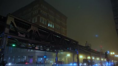 Sisli bir gecede Yükseltilmiş Pist 'ten geçen tren. Chicago şehir merkezinde metro. Geniş açı. Yüksek kalite 4k görüntü