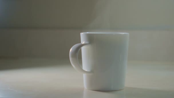 Una Mano Toma Una Taza Blanca Con Café Mesa Primer — Vídeos de Stock