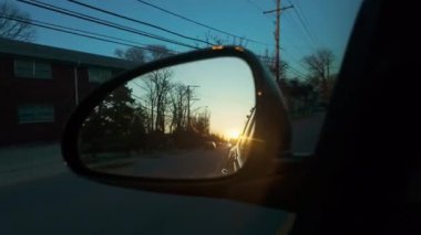 Güneş akşam araba aynasına yansıyor. Bir arabanın dikiz aynasının görüntüsü. Yüksek kalite 4k görüntü