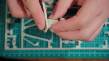 Çizimler ve talimatlara göre insan derleyici plastik modeli masada. Ellerin görüntülerini kapat. Yüksek kalite 4k görüntü