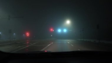 Arabanın görüntüsü ve trafik lambası gece ve siste çalışıyor. Yüksek kalite 4k görüntü